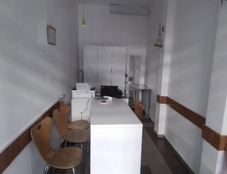 Pamje nga brenda e zyrës, me tavolinë, karrige dhe pajisje pune